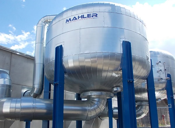 Large MAHLER AGS absorber tank with insulated, spherical-ended vessel mounted on blue steel supports and connected to silver ducting/piping outdoors.