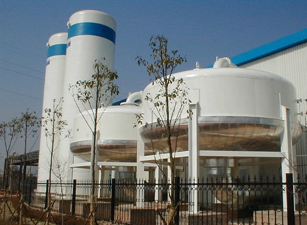 MAHLER AGS oxygen VPSA system with large white cylindrical adsorption vessels and towers outdoors at an industrial site.