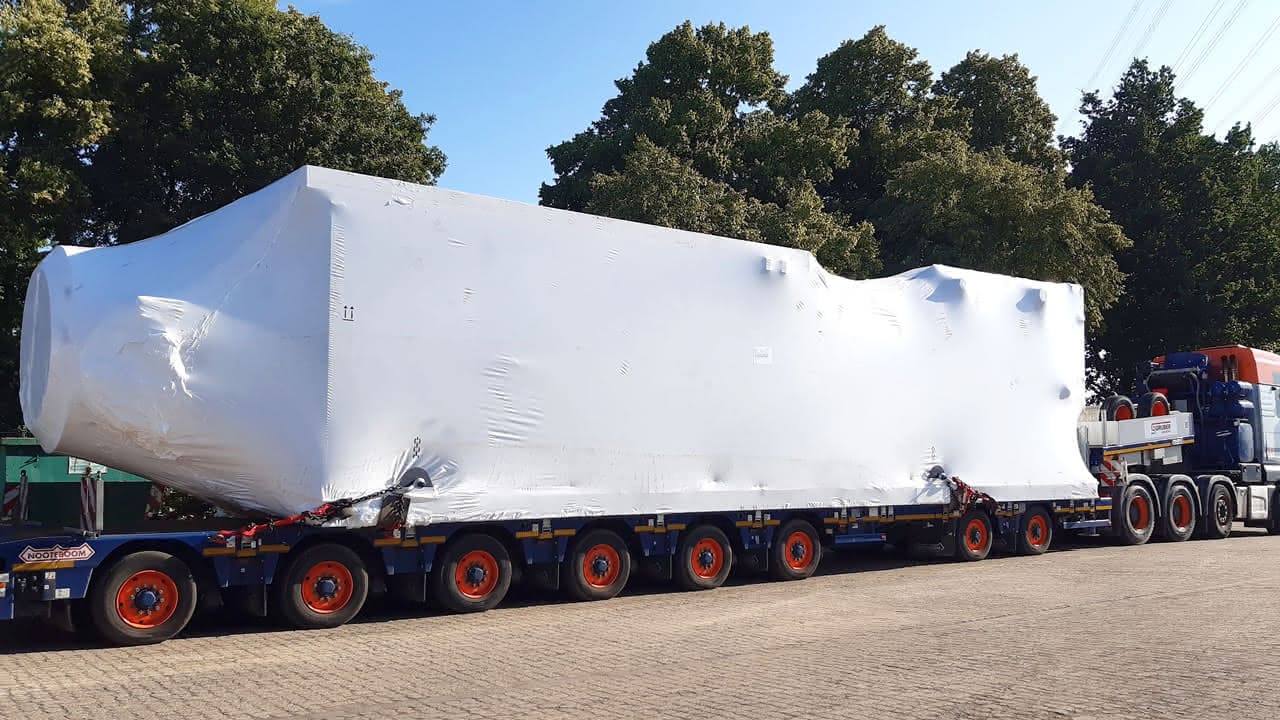 Oversized MAHLER plant component wrapped for protection and transported on a multi-axle heavy-haul trailer.