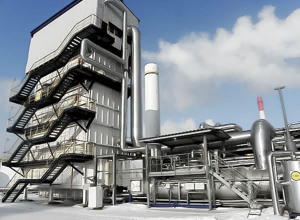 Exterior view of a MAHLER Hydroform C hydrogen plant module with multi-level staircase, connected piping, and industrial processing equipment under a partly cloudy sky.