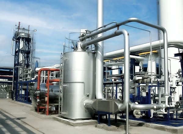 MAHLER Hydroform M gas treatment unit with large stainless-steel vessel, interconnected pipes and valves, installed outdoors at an industrial plant under a blue sky.