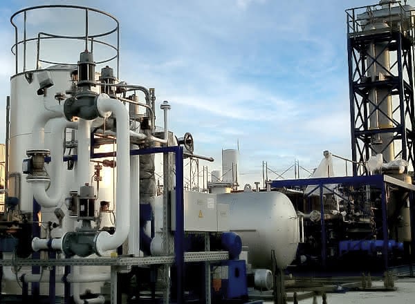 Industrial MAHLER Hydroform M gas-processing module outdoors, showing large white vertical vessel with curved piping, blue steel frame, and a horizontal storage tank under a clear sky.