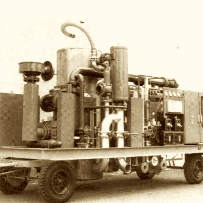 Vintage sepia photo of an early MAHLER mobile gas plant mounted on a wheeled trailer, with tall cylindrical vessels, piping, and control equipment visible on the skid.