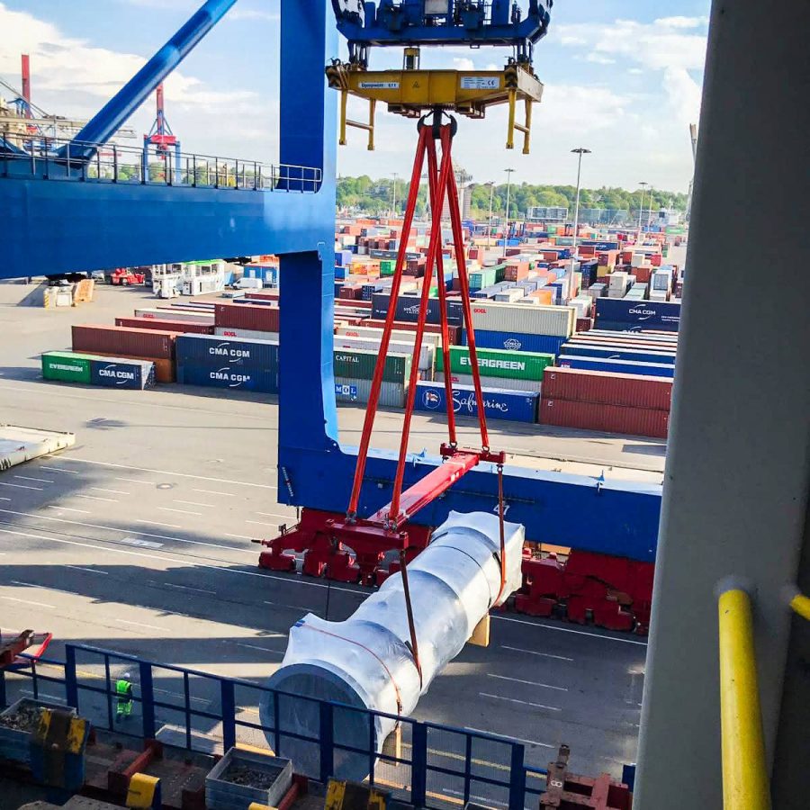 MAHLER plant component being lifted by a port crane with heavy-duty slings during international cargo loading.